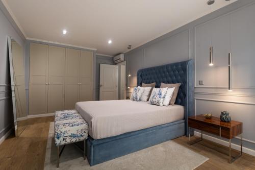 1 dormitorio con 1 cama grande y cabecero azul en Azor Central Lodge en Ponta Delgada