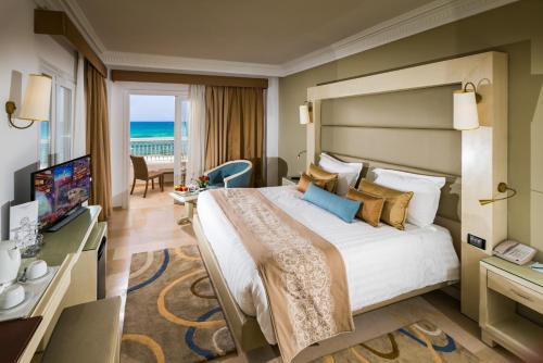 una camera d'albergo con un grande letto e una TV di Sousse Palace Hotel & Spa a Sousse