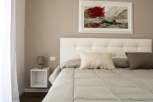 a bed in a bedroom with a picture on the wall at Home Suites Home in Salionze