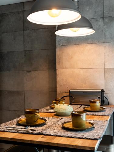 a table with plates and cups on top of it at Azor Central Lodge in Ponta Delgada
