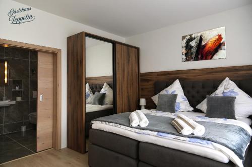 1 dormitorio con 1 cama grande y espejo en Gästehaus Zeppelin, en Uhingen