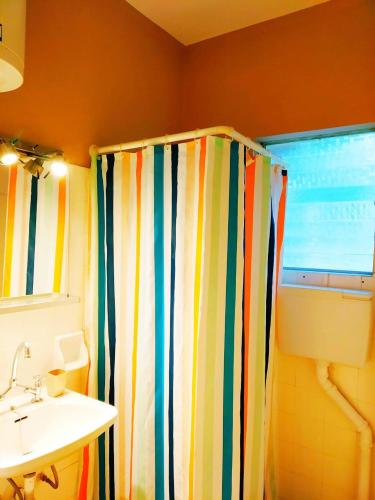 a bathroom with a colorful shower curtain and a sink at Villa Artemida in Selianitika