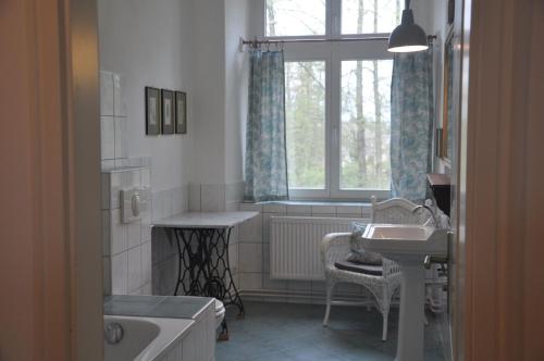 a bathroom with a sink and a tub and a window at Apartment für 4 Personen im Schloss Neuhausen in Berge