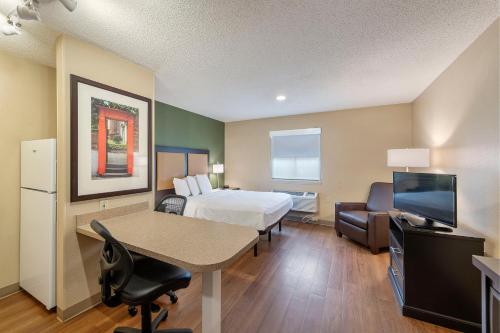 a hotel room with a bed and a desk and a tv at Extended Stay America Select Suites - Charlotte - Tyvola Rd - Executive Park in Charlotte