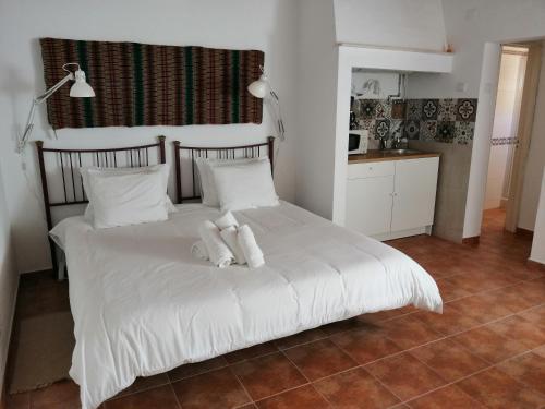 1 dormitorio con 1 cama con sábanas y almohadas blancas en Vitória House en Évora