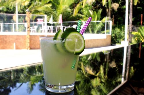 a drink with a slice of lime on a table at Murakami Pousada in Itanhaém