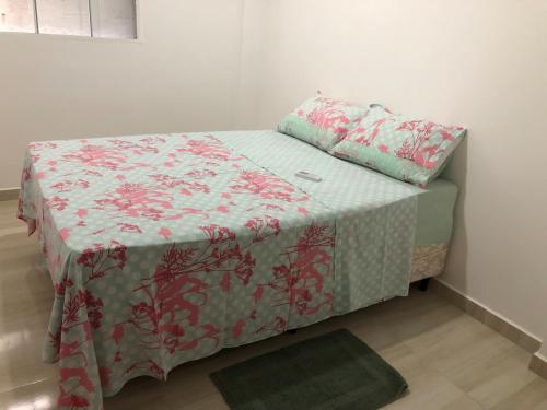 a bed in a room with a blanket on it at Apartamento Aconchegante em Foz in Foz do Iguaçu