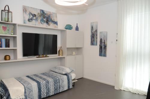 sala de estar con TV de pantalla plana en la pared en Exclusive Home 2, en Misano Adriatico