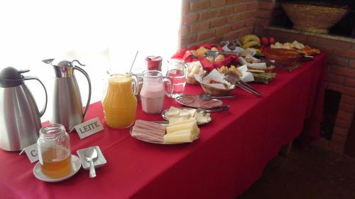een rode tafel met eten en drinken erop bij Pousada Recanto da Vitória in Gonçalves