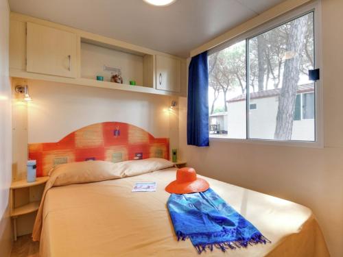 a bedroom with a bed with an orange hat on it at Mobile Home in Cesenatico by Adriatic Sea in Cesenatico