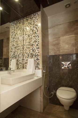 a bathroom with a sink and a toilet at Hotel Delhi 55 -City Center in New Delhi