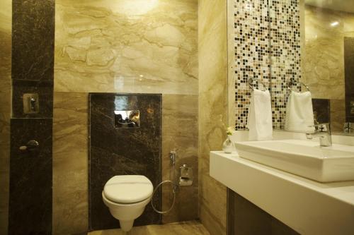 a bathroom with a toilet and a sink at Hotel Delhi 55 -City Center in New Delhi