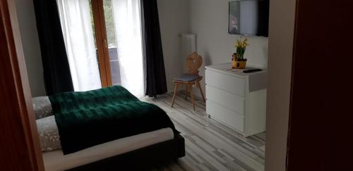 1 dormitorio con 1 cama, vestidor y ventana en Pension Lischenhof, en Ehrwald