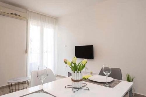 a dining room with a table with two wine glasses at Ane in Zadar