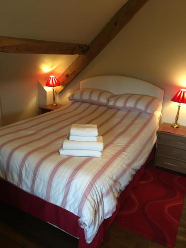 a bedroom with a bed with towels on it at Lapwing Cottage in Stoke on Trent