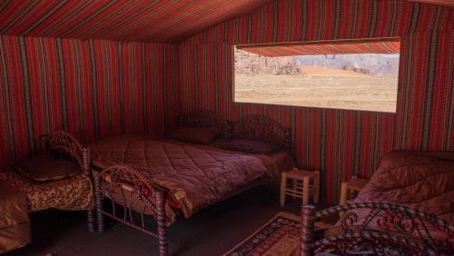 a red room with a bed and a window at Arabian Nights in Wadi Rum