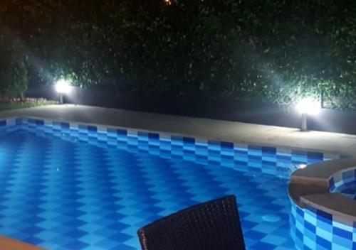 una piscina por la noche con dos sillas en Casa Quinta familiar piscina privada Girardot, en Girardot