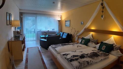 een slaapkamer met een bed en een stoel in een kamer bij Landhaus Schwaben in Schönmünzach