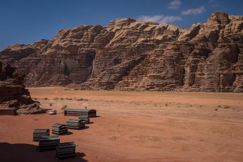 a row of benches in the desert near a mountain at Arabian Nights in Wadi Rum