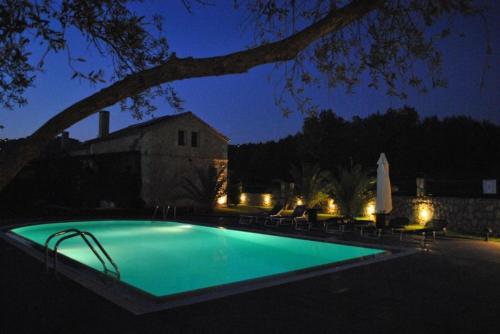 a swimming pool in a yard at night at 5 Stars Villas in Svoronata