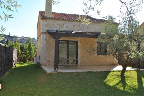 a stone house with a bench in a yard at 5 Stars Villas in Svoronata