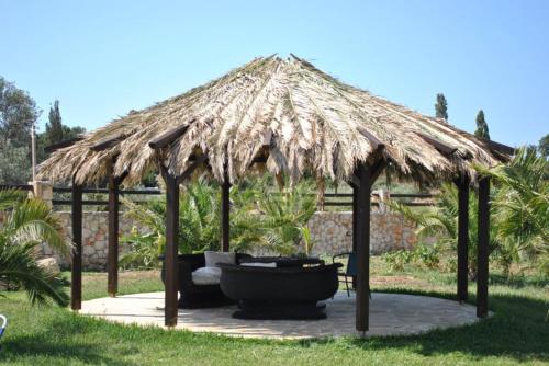 a large hut with a bench and a tub under it at 5 Stars Villas in Svoronata