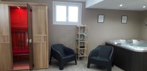 a bathroom with two chairs and a sink and a tub at la tiny house de l'aa in Bourthes