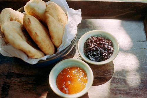 a table with a bowl of bread and two bowls of sauce at The Postcard Cuelim, Goa in Cansaulim