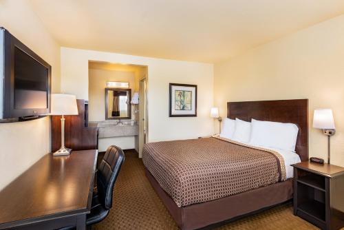 een hotelkamer met een bed en een bureau bij Key Inn and Suites in Tustin