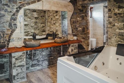a stone bathroom with two sinks and a tub at Stella Maris Resort in Camogli