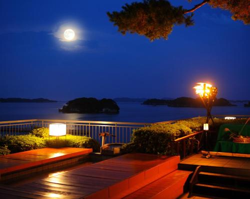 a moonlit deck with a view of the water at night at Komatsu-kan Kofu-tei in Matsushima