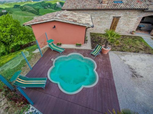 una vista aérea de una terraza con sillas y una casa en Flat on a farm with swimming pool and many activities, en SantʼAngelo in Vado