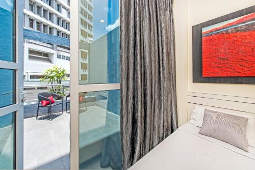 a bedroom with a bed and a large window at Hotel 81 Elegance in Singapore
