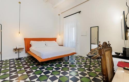 a bedroom with a bed and a checkered floor at A.D. 1768 Boutique Hotel in Ragusa