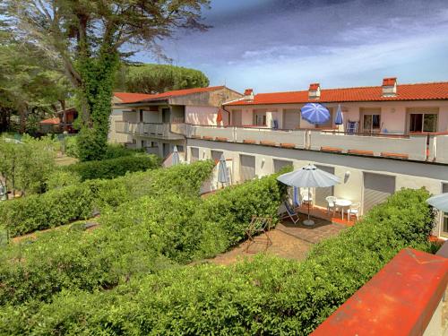 a balcony of a building with a bench and an umbrella at Belvilla by OYO Aria in Santa Liberata