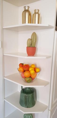 a white refrigerator with a bowl of fruits and vegetables at Vakantiehuis Katwijk in Katwijk