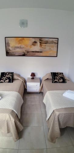a room with two beds and a painting on the wall at Gianni Holiday Home in Pieta