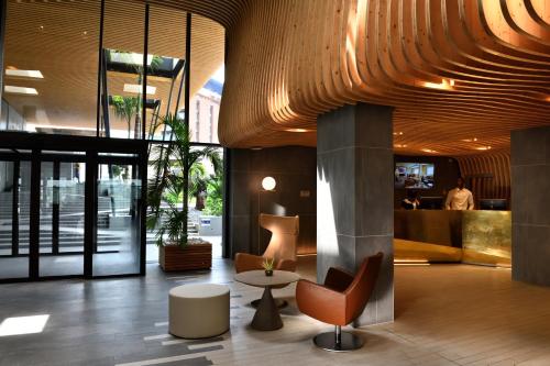 a lobby with a table and chairs in a building at Pullman Abidjan in Abidjan