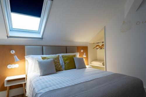 a bedroom with a bed with a window above it at Alojamento da Vila in Valença