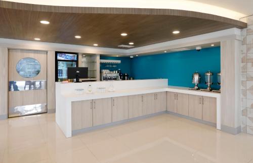 a lobby with a bar with a blue wall at Hotel Diego de Almagro Viña del Mar in Viña del Mar