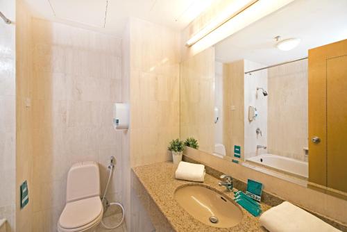 La salle de bains est pourvue de toilettes, d'un lavabo et d'un miroir. dans l'établissement Hotel 81 Tristar, à Singapour