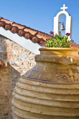 a large stone vase with a cross on top of a church at Elixirion Guest House in Karavostasion