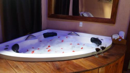 a bath tub with red debris in a room at POUSADA BELA HELENA in Visconde De Maua