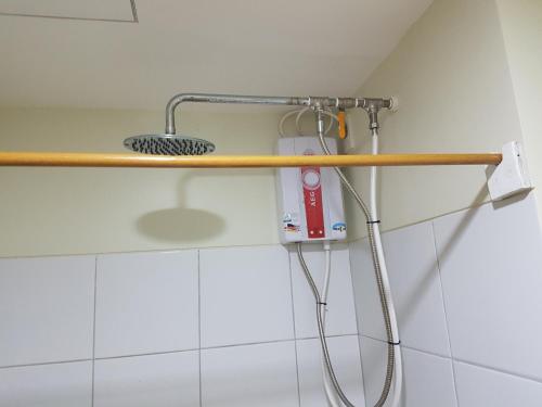 a shower in a bathroom with a wooden shelf at KC Studio 7 at Horizon 101 Cebu in Cebu City