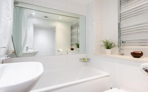 a white bathroom with a sink and a mirror at Classic Two-Bedroom Apartment Pimlico in London