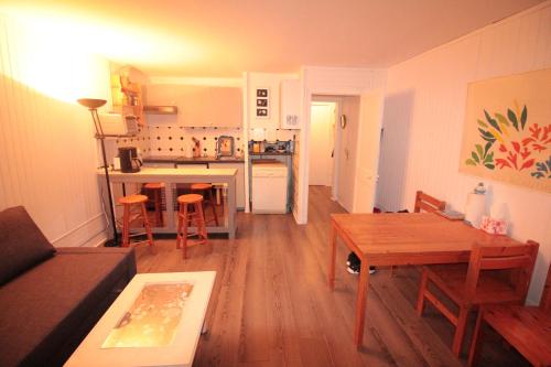 sala de estar con mesa y cocina en On The Beach, en Saint-Aubin-sur-Mer