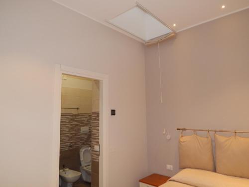 a bedroom with a bed and a bathroom with a window at A due passi dal mare in Marina di Schiavonea