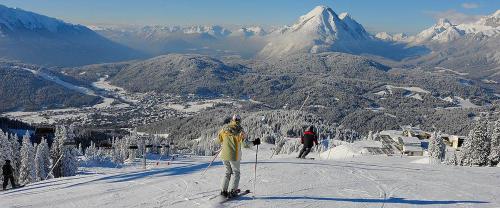 a group of people skiing down a snow covered mountain at ALPENFREUND in Mittenwald