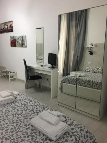 a bedroom with a bed and a desk with a computer at Affittacamere La Giara in Porto Empedocle