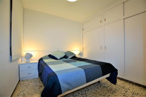 1 dormitorio con 1 cama con sábanas azules y blancas en Villaservice - Leonor, en Calafell